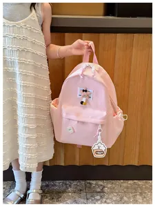 Pink nylon kids backpack with stitched letter patch and star charm detail