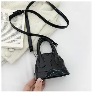 Détail du mini sac à main noir brillant avec surpiqûres losanges et finitions métalliques