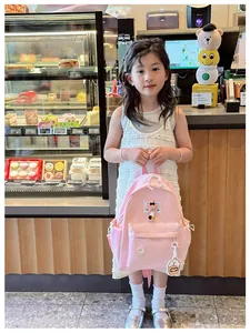 Close-up of pink nylon kids backpack with stitching detail and side bottle pocket