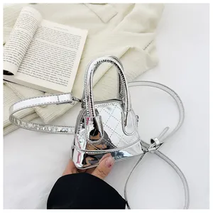 Gros plan du micro sac argenté matelassé avec logo VINAL sur un fond en tissu tricoté