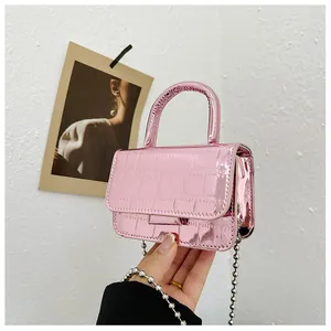 Close-up of metallic pink mini bag with crocodile texture and silver ball chain strap