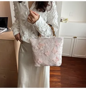 Details von der Spitzentextur, 3D-Schmetterlingsapplikationen und Bambusgriff am Tasche