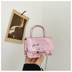 Detailed macro of a metallic pink mini bag with crocodile texture and silver bead chain