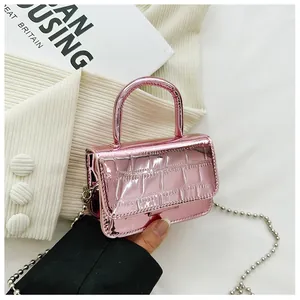 Detailed view of pink croc-embossed mini handbag with silver bead chain strap and glossy finish