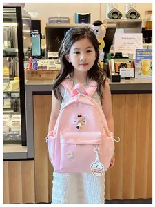 Detailed view of pink children backpack featuring large capacity compartments and cute charms