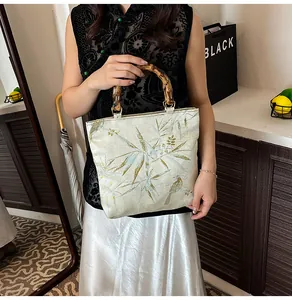 Detail der Retro-Tragetasche mit Bambusgriff und grüner Blattstickerei im China-Stil