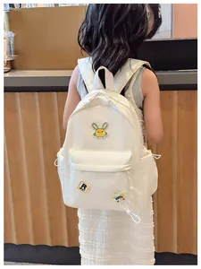 Detailed view of cream nylon kids backpack with cute rabbit embroidery and star charm