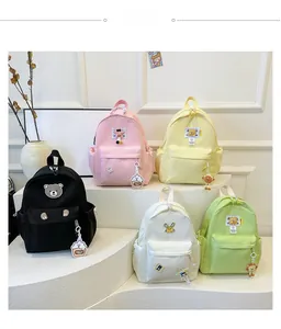 Kids nylon backpacks shown in five pastel colors with cute cartoon patches and embroidery