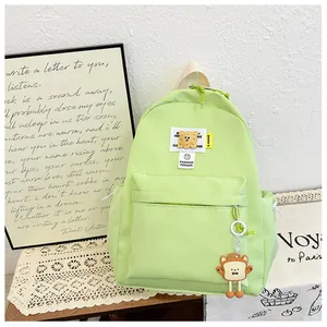 Close-up of mint green canvas backpack with toast charm and fashion badge details