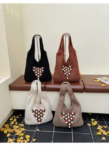 Detail of four knit tote bags with colorful festive pom-poms in various winter colors