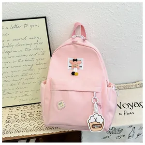 Detailed view of pink school backpack with plush star patch and cupcake charm