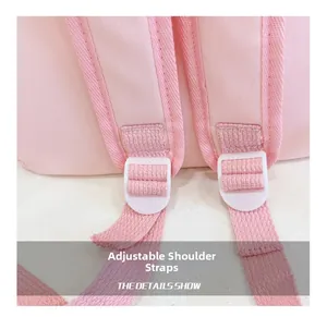 Detail of adjustable wide shoulder straps with white plastic buckle on pink nylon backpack