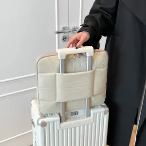 Gesteppte cremefarbene Puffertasche mit Kofferband am Trolleygriff für die Reise