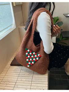 Close-up of brown knit tote bag featuring a colorful pom-pom Christmas tree pattern