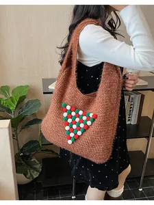 Detail shot of winter knit tote bag featuring a colorful pom-pom Christmas tree design
