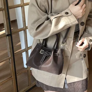 Sac seau en cuir mat marron foncé avec coutures blanches et bandoulière amovible