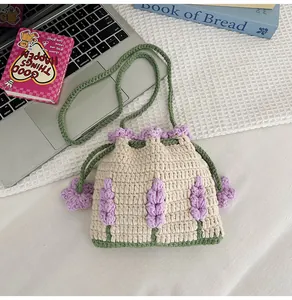 Detalle macro del bolso cubo de punto crema con flores de lavanda y correa verde