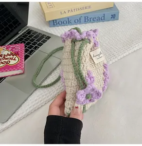 Detalle del bolso de ganchillo hecho a mano con flores púrpuras y correa verde