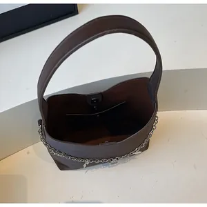Top view of brown bucket tote bag showing magnetic closure and silver chain charm