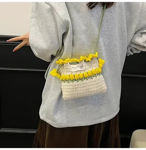 Primer plano detallado de bolso cubo de ganchillo con flores amarillas y correa verde
