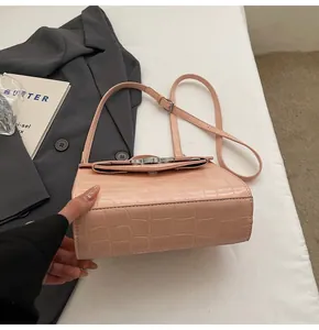 Détail du sac à main en cuir rose imitation crocodile avec fermoir argenté et bandoulière