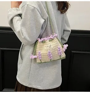 Detalle del bolso tipo cubo de ganchillo hecho a mano con flores de lavanda tejidas