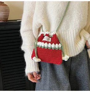 Primer plano detallado del bolso de punto rojo hecho a mano con patrones de tulipanes