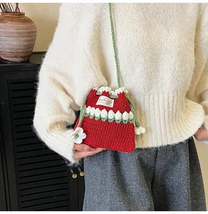 Detalle de un bolso cubo de ganchillo floral hecho a mano con texturas de punto rojo