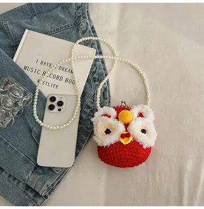 Detail of red knit lion dance crossbody bag with white pearl strap and metal clasp