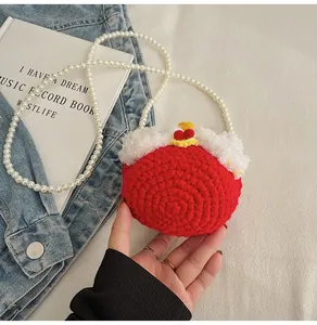 Detail of red handmade crochet mini bag with faux fur trim and pearl bead strap