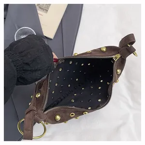 Top view of brown suede crescent bag with gold rivets showing the inner compartment