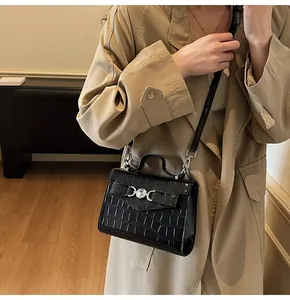 Détail de la texture crocodile noir et boucle argentée sur un sac de style Kelly
