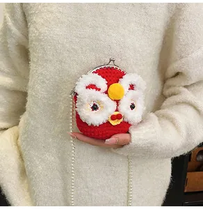 Detail of red knit lion bag with faux fur eyes and white pearl shoulder strap