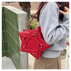 Detail of red star-shaped crossbody bag featuring metallic rivets and unique textured leather