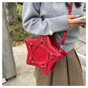 Detail of red star-shaped leather crossbody bag worn with a casual winter outfit