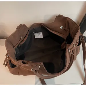 Vista superior del interior espacioso con bolsillo con cremallera del bolso tote de ante marrón