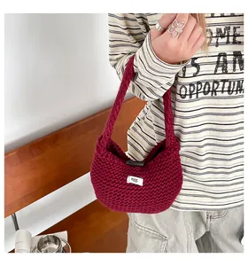 Dettaglio della borsa tote in maglia bordeaux con trama spessa e bottone in legno