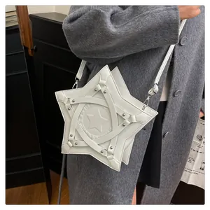 Detailed view of white star-shaped shoulder bag with studs and straps on a model
