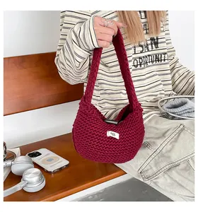 Dettaglio della borsa tote in maglia bordeaux con un'etichetta bianca minimale del marchio
