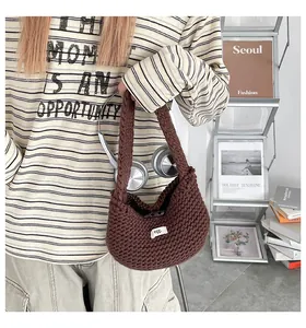 Dettaglio della borsa tote in maglia marrone scuro con trama a uncinetto ed etichetta