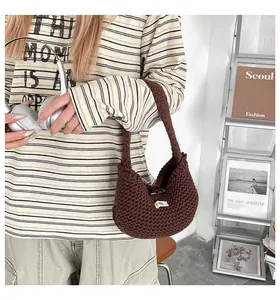 Dettaglio della borsa tote in maglia marrone scuro con etichetta e chiusura oliva