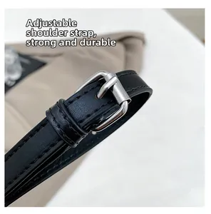 Close-up of adjustable leather shoulder strap with polished silver buckle and stitching