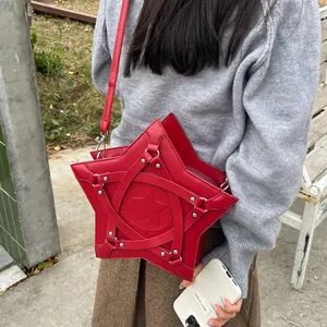 Star-shaped red crossbody bag with silver rivets and crisscross strap design on model