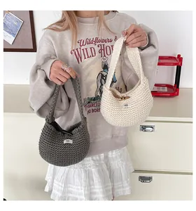 Dettaglio di borse tote in maglia con fibbia in corno di legno e etichetta logo in grigio e crema