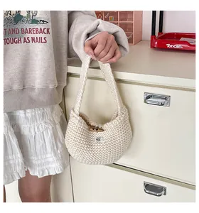 Dettaglio della borsa tote in maglia panna con bottone in corno di legno ed etichetta 'egg.'