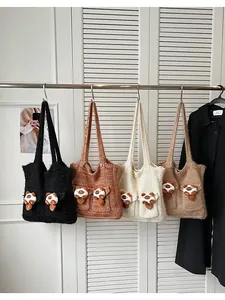 Dettaglio di quattro borse in maglia colorate con ciondoli a forma di panda peluche