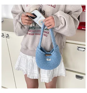 Dettaglio della borsa tote in maglia azzurra con bottone in legno ed etichetta tessuta