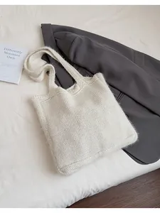Dettaglio della borsa tote in maglia bianco crema con trame di filato spesso