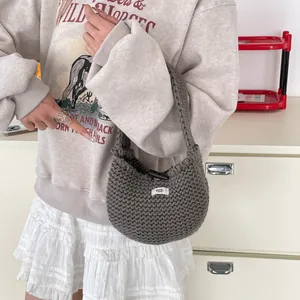 Borsa tote in maglia grigia con etichetta egg. presentata in un set di moda casual
