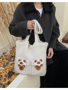 Dettaglio della borsa tote in maglia bianca con toppe di gatto carino e texture morbide